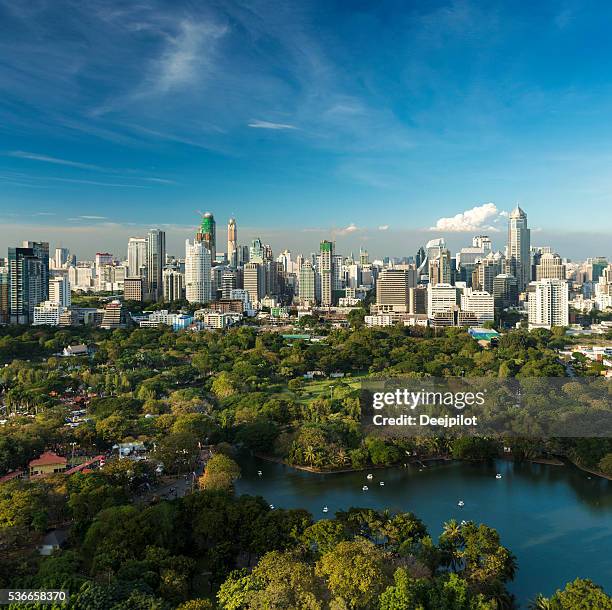 lumphini park and the downtown bangkok city skyline thailand - lumpini park stockfoto's en -beelden