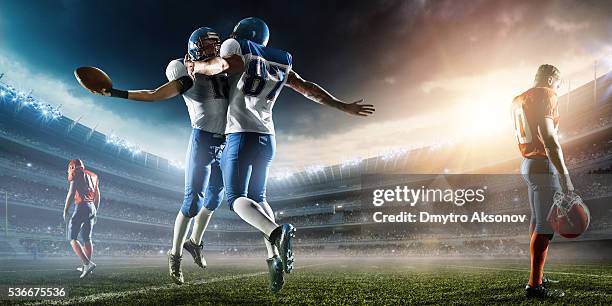 zwei fußball-spieler feiern sie ihren sieg - touchdown celebrate stock-fotos und bilder