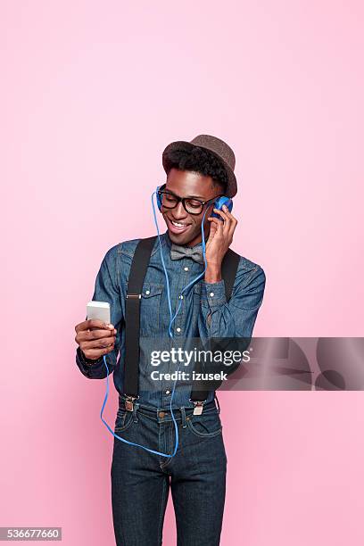 glücklich afro amerikanische mann hören sie musik mit smartphone - how we listen to music stock-fotos und bilder