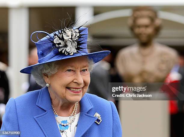 Queen Elizabeth II smiles as she walks past a bronze bust of herself during a visit to the Honourable Artillery Company on June 1, 2016 in London,...