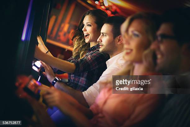 group of people playing slots in casino. - casino interior stock pictures, royalty-free photos & images
