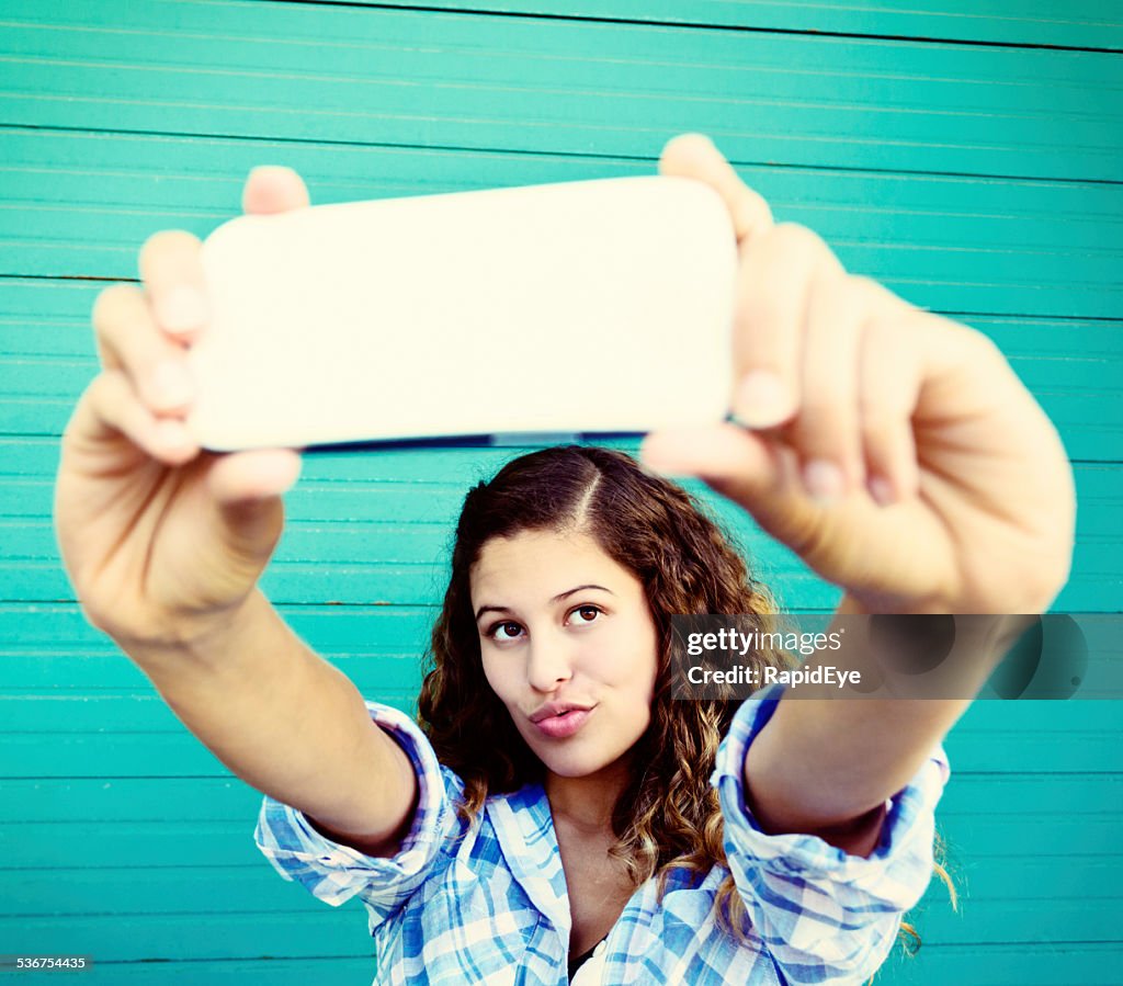 Curly-haired beauty takes trout-pout selfie