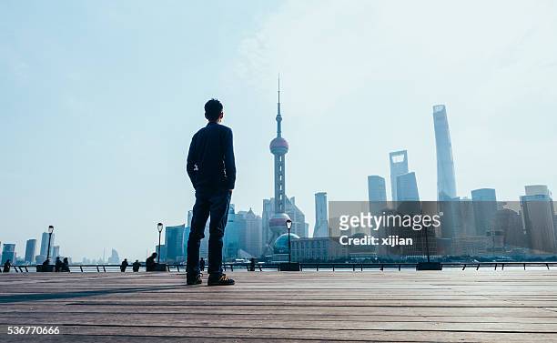 man looking at shanghai skyline - people shanghai stockfoto's en -beelden
