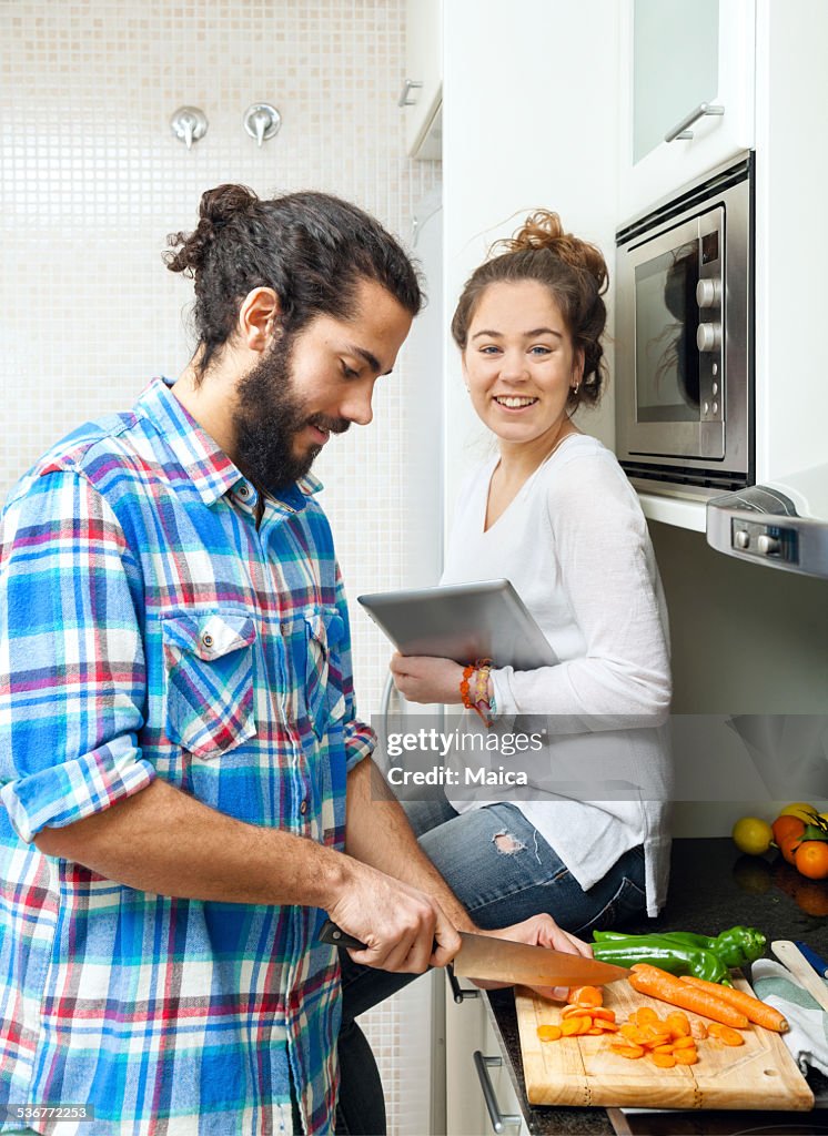 Young couple cooking with internet recipe