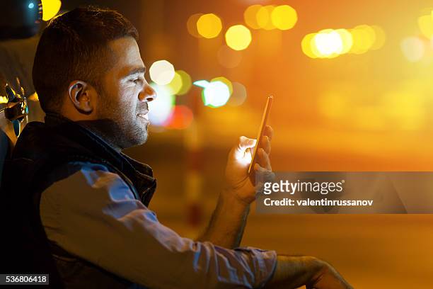 young man sitting next to his cat at night - mobile phone in hand driving stock pictures, royalty-free photos & images