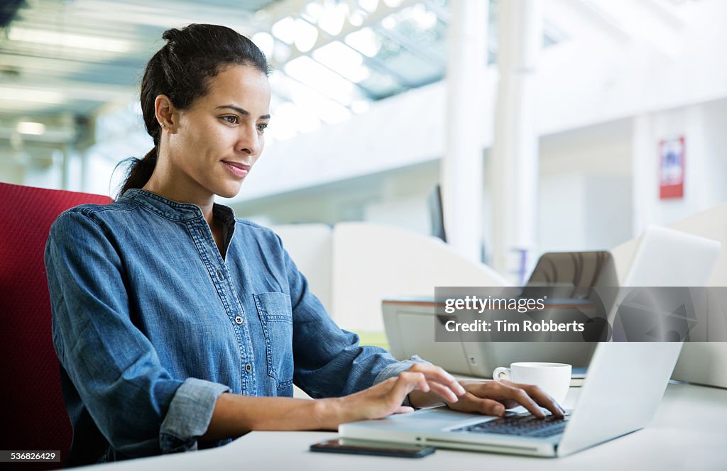 Woman using laptop at office desk