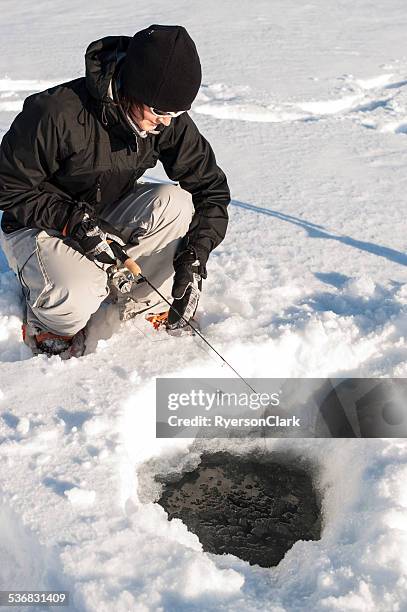 woman ice fishing, great slave lake, yellowknife, northwest territories. - great slave lake stock pictures, royalty-free photos & images