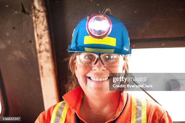 mature woman underground miner with headlamp. - mijnwerker stockfoto's en -beelden