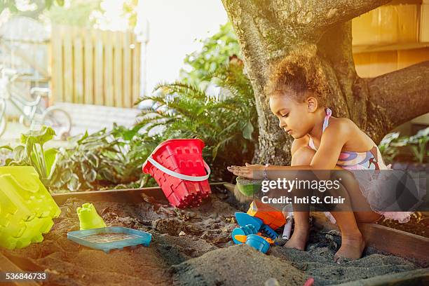 girl in tutu playing in sandbox in yard - 1 kid 1 sandbox stock-fotos und bilder
