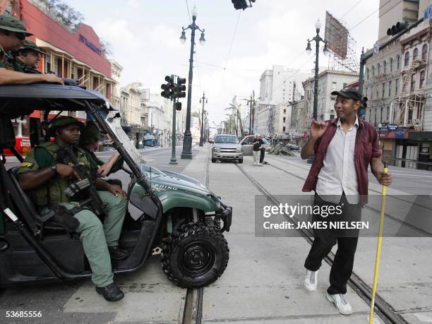 New Orleans, UNITED STATES: A man walks past law enforcement personnel 31 August 2005 in New Orleans, Louisiana, in the aftermath of Hurricane...