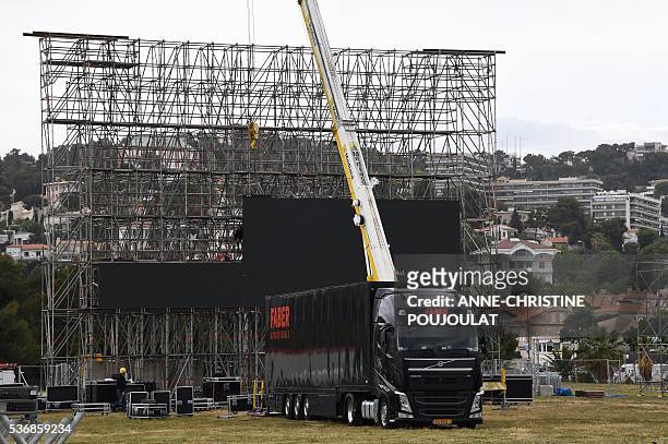 Workers install giant screens in the fanzone site for the UEFA Euro 2016 on the Prado beaches in Marseille where supporters will gather to watch the...