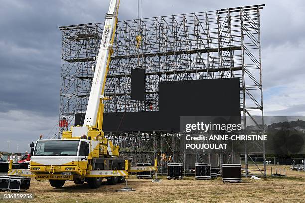 Workers install giant screens in the fanzone site for the UEFA Euro 2016 on the Prado beaches in Marseille where supporters will gather to watch the...