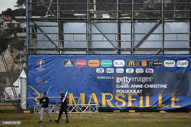 Workers install the fanzone site for the UEFA Euro 2016 on the Prado beaches in Marseille where supporters will gather to watch the games, on June 1,...