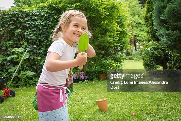 girl gardening, holding trowel in hands - alexandra dost stock-fotos und bilder