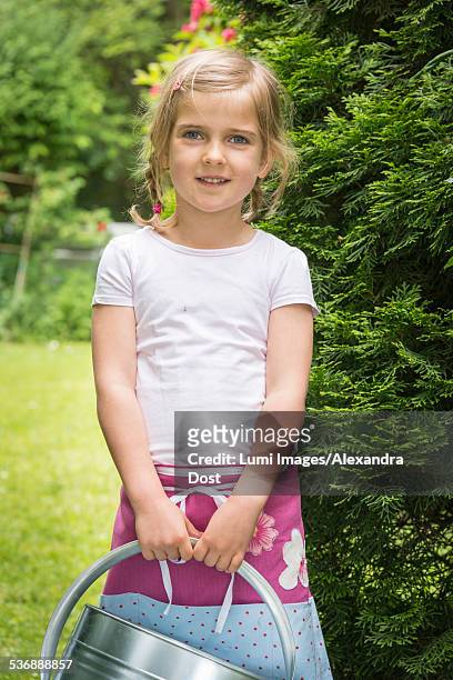 little girl gardening, holding a watering can - alexandra dost stock-fotos und bilder
