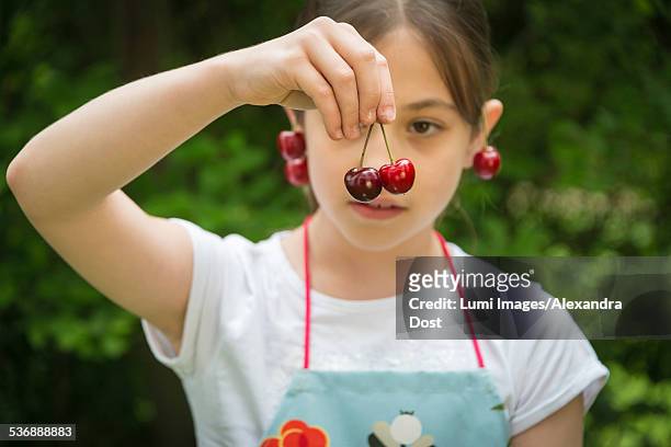 girl with cherries dangling from her ears - alexandra dost stock-fotos und bilder
