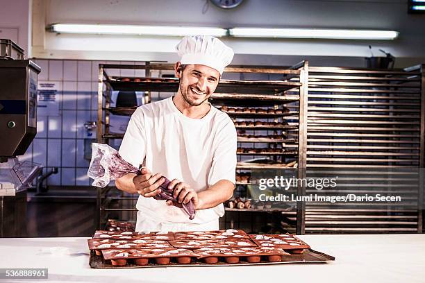 confectioner working with icing bag in bakery - chocolatier photos et images de collection