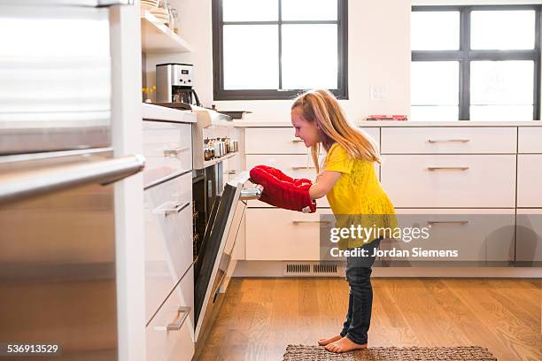 a young girl wathcing cookies bake. - mt cook fotografías e imágenes de stock