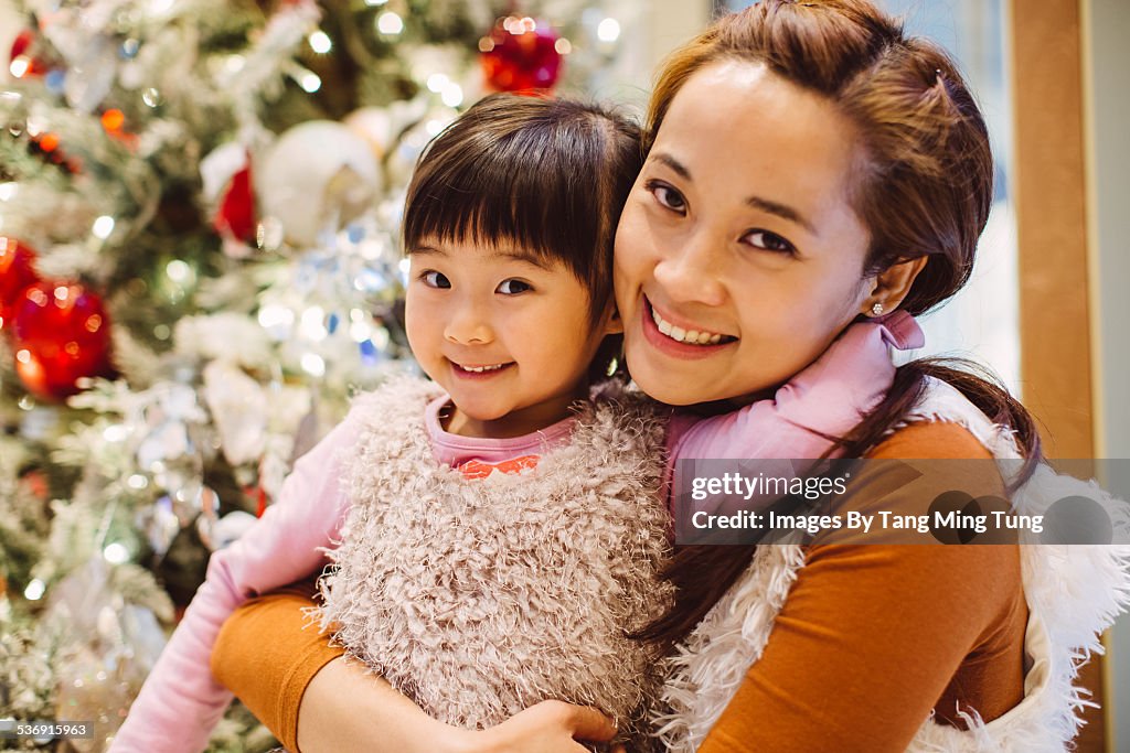 Mom & daughter looking at camera joyfully at mall