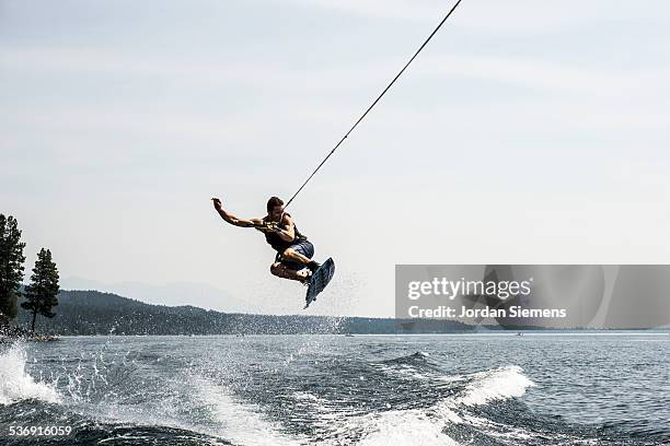 wake boarding on a lake - wakeboarden stock-fotos und bilder