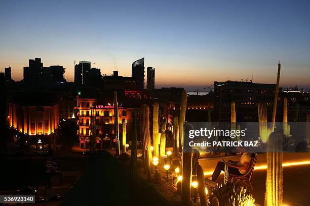 Man works on his laptop as he is sits on the terrasse of a loft apartment in downtown Beirut on June 1, 2016. / AFP / PATRICK BAZ