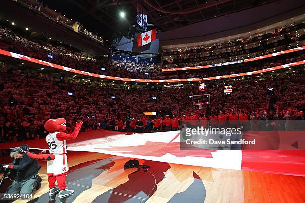 The Raptor, stands on the court with the Canadian Flag before game four of the Eastern Conference Finals against the Cleveland Cavaliers on May 23,...