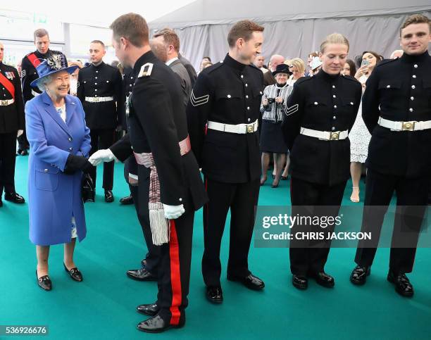 Britain's Queen Elizabeth II meets guests during a visit to the Honourable Artillery Company in London on June 1, 2016. The engagement marks the...