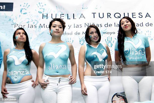 Women show their bodypaintings during the closing campaign of the "Partido Nueva Alianza" party in Mexico City on May 31, 2016. Girls with tight...