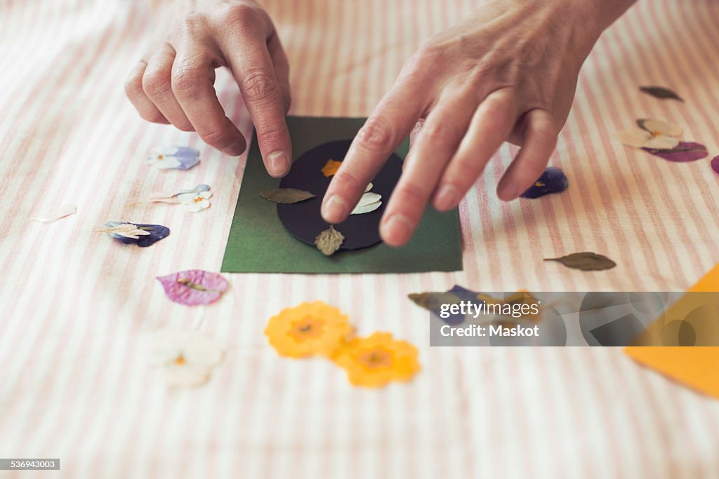 Cropped image of woman making paper craft product on table