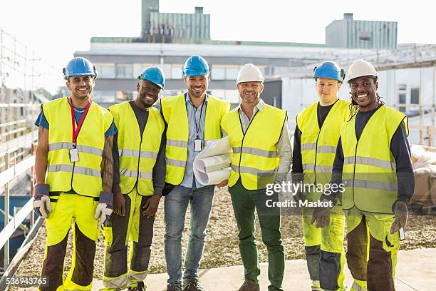 portrait of confident construction team standing together at site - portrait man building stock pictures, royalty-free photos & images