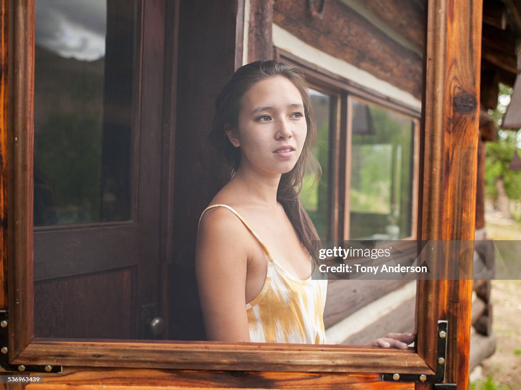 Young woman at cabin in the forest
