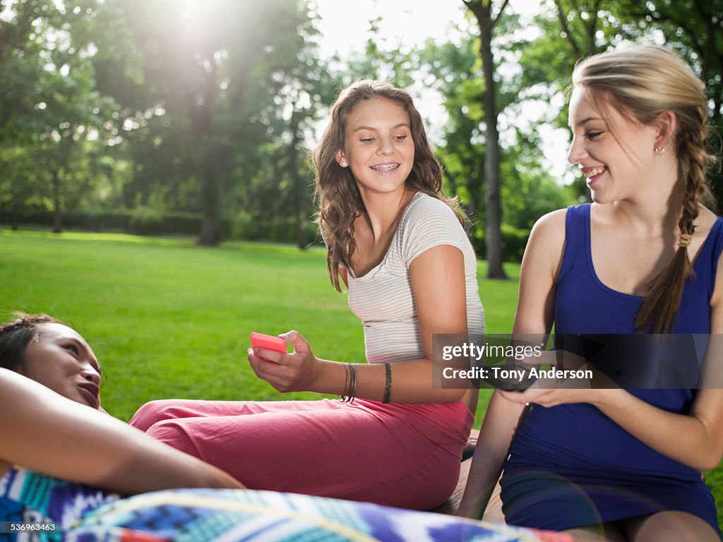 Teenage girls outdoors in park with phones