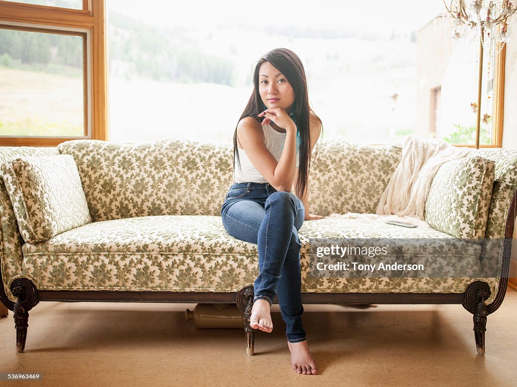 Young woman on sofa near window at home