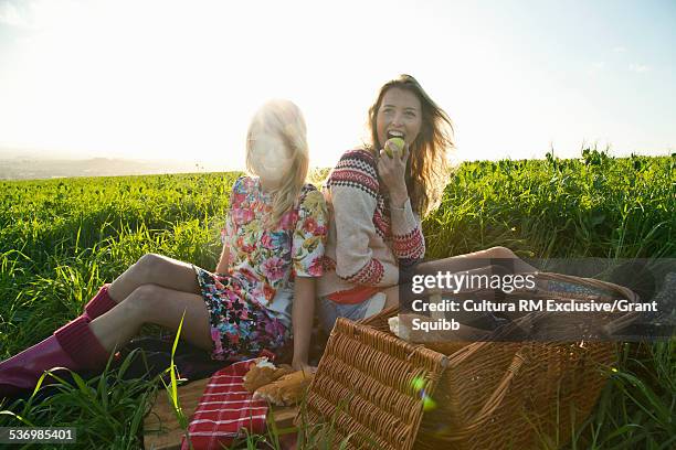 two young women friends having a picnic in rural field - south west england fotografías e imágenes de stock