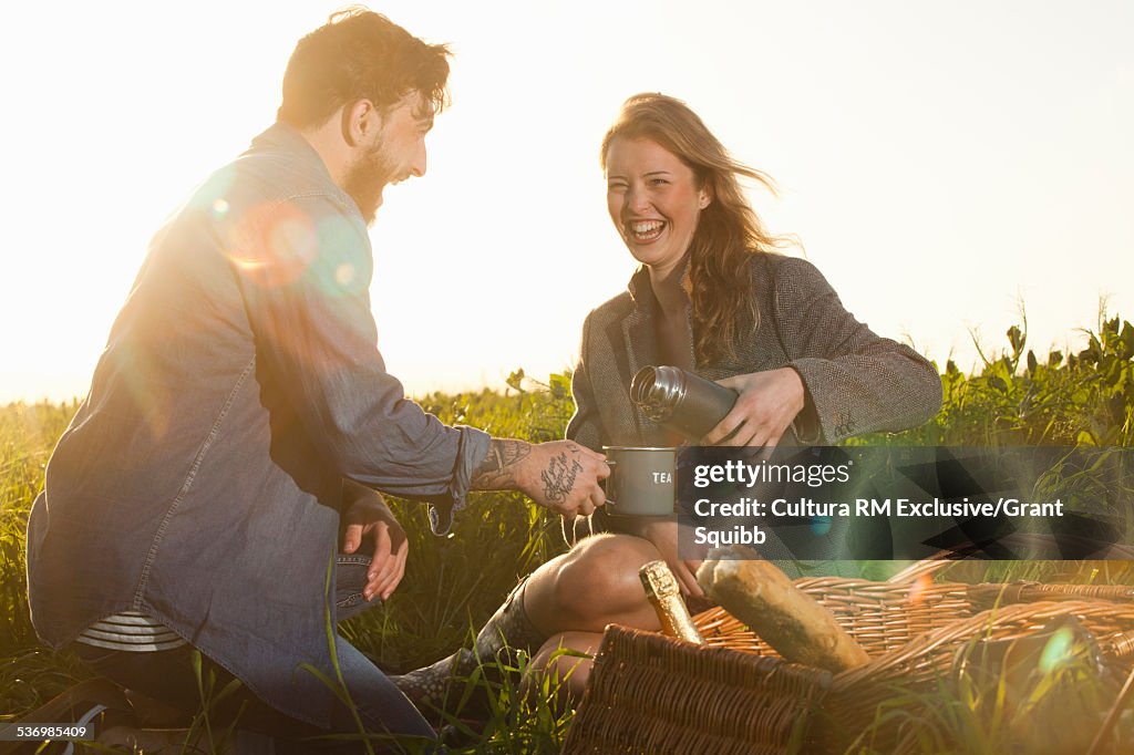 Young couple sharing picnic in rural field