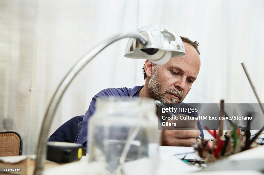 Mature man sitting at desk, writing