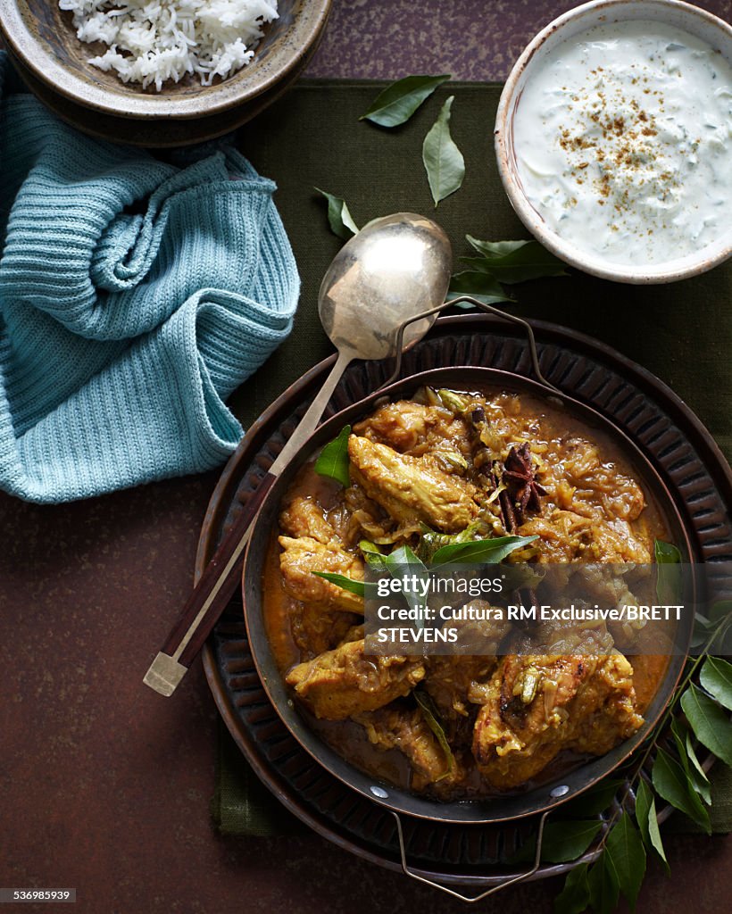 Bowl of chicken peratal curry with yogurt and steamed rice