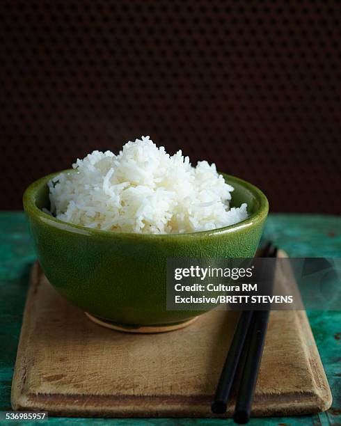 bowl of steamed rice with chopsticks on chopping board - steamed stock-fotos und bilder