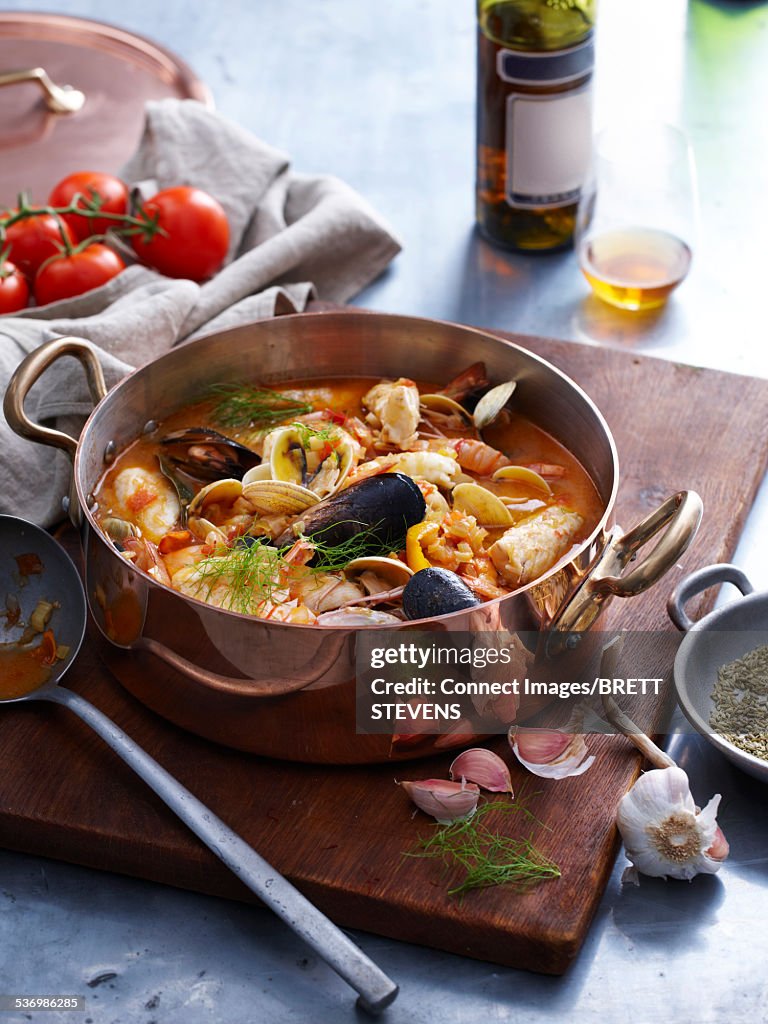 Pan of bouillabaisse, fish stew on chopping board