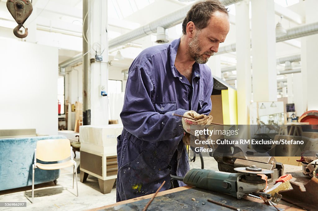 Artist constructing artwork from metal