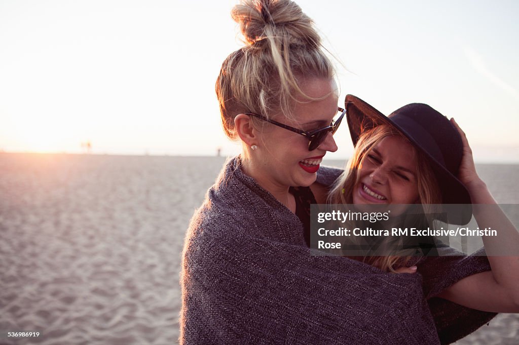 Two female friends hugging on beach