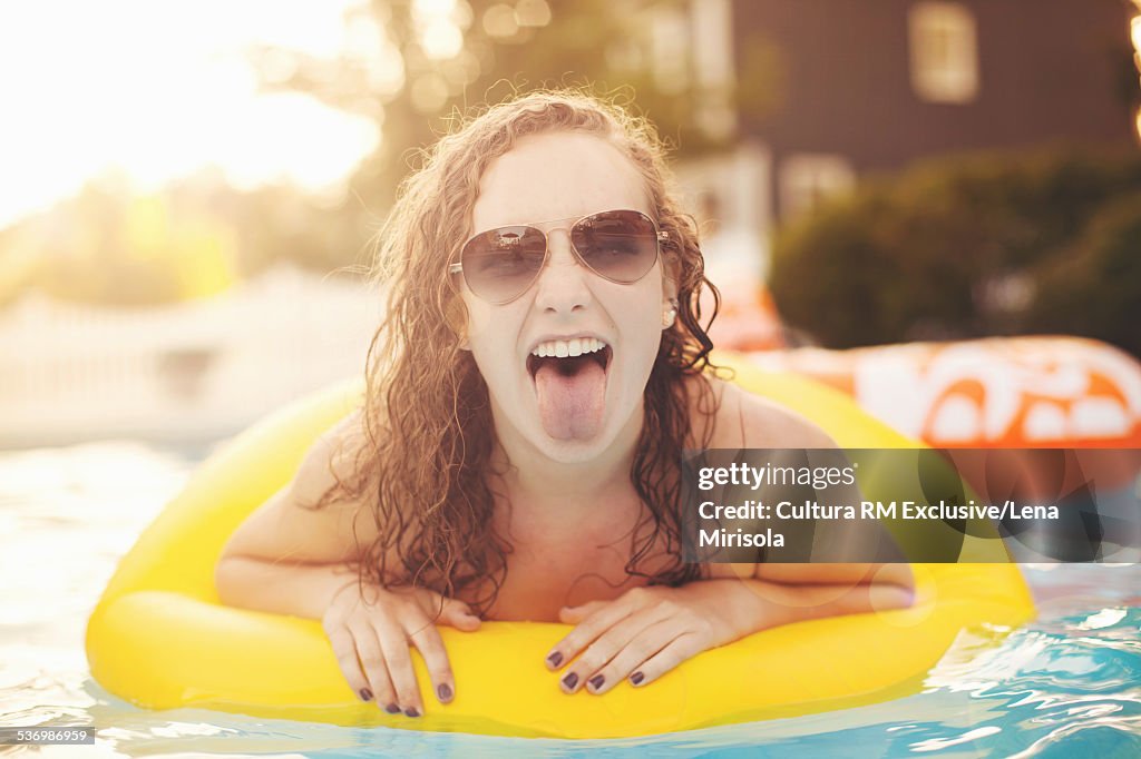 Young woman in inflatable lounger at pool party
