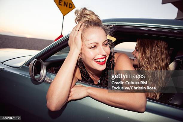 young woman leaning out of car window, smiling - leaning on elbows stock pictures, royalty-free photos & images