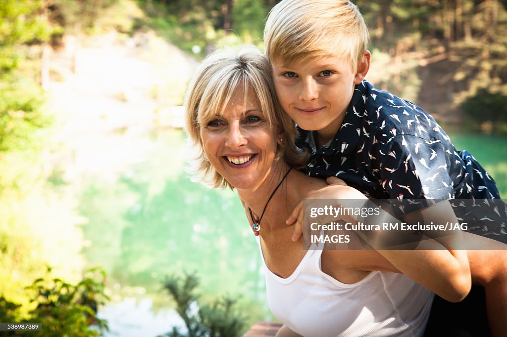 Mother giving son piggyback ride, The Blue Pool, Wareham, Dorset