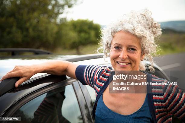 smiling woman by car - naast stockfoto's en -beelden