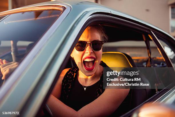 young woman in car, shouting - transportation occupation stock pictures, royalty-free photos & images