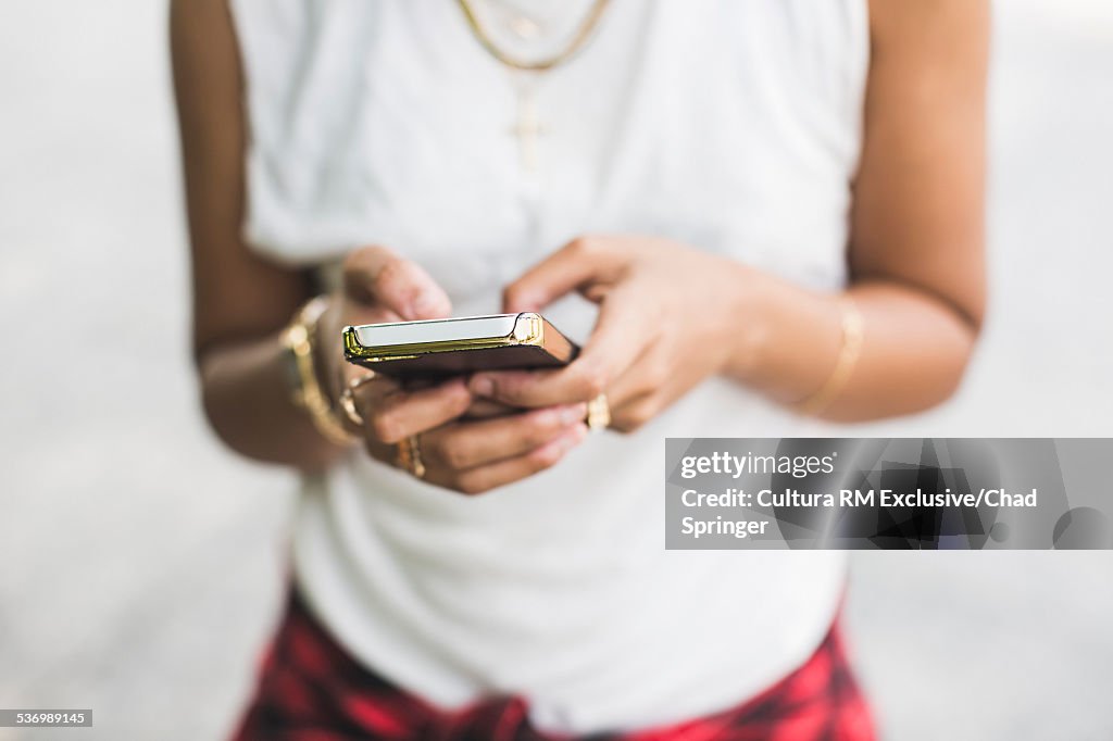 Cropped shot of young woman texting on smartphone