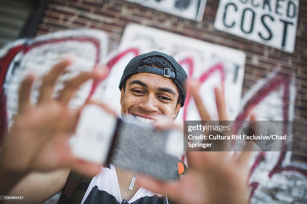 Young man photographing with smartphone