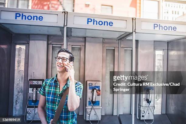 man talking on phone in street, new york city, us - pay phone stockfoto's en -beelden