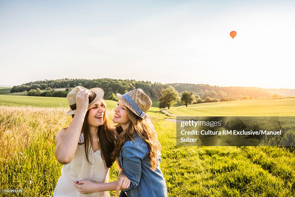 Two young women, laughing and fooling around in field